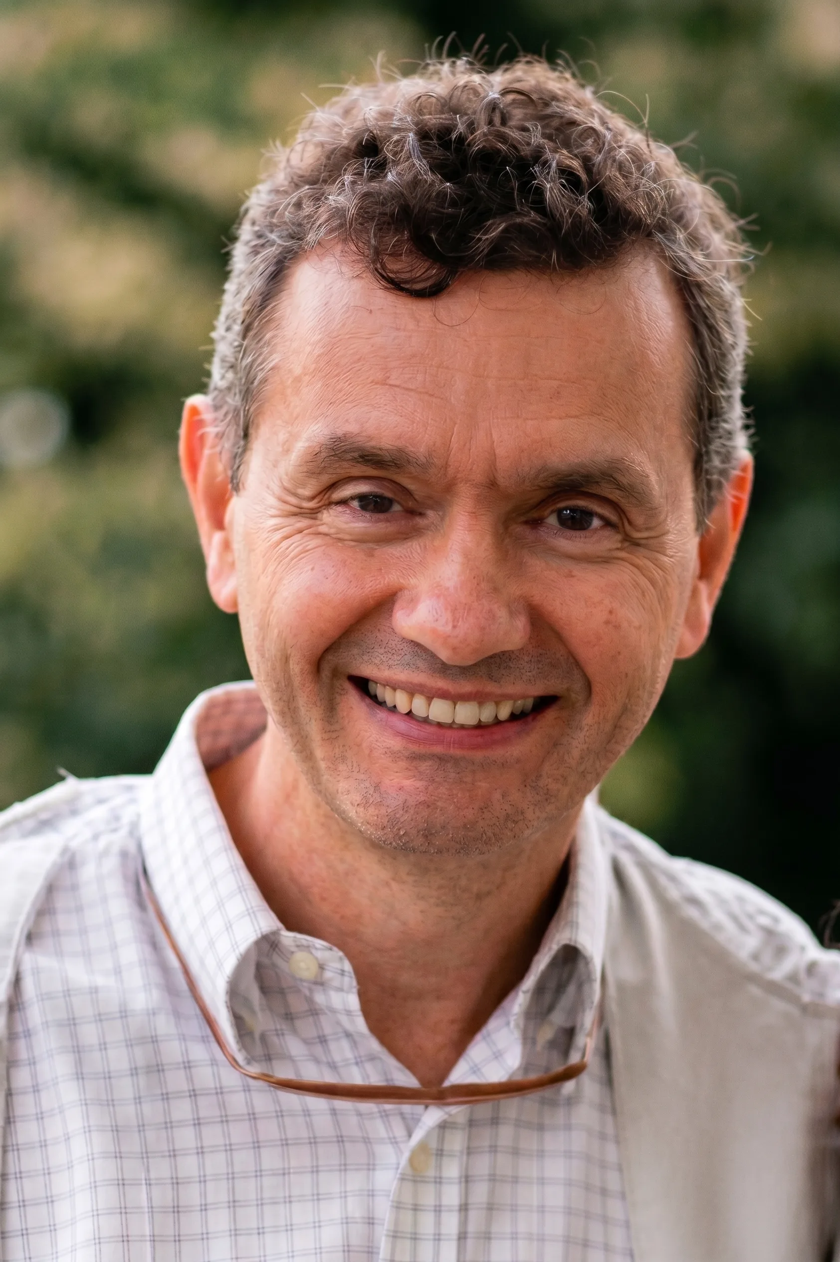 Dr. Degmar Ferro, médico, sorrindo, em retrato ao ar livre.